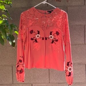 Pink blouse with embroidered details.